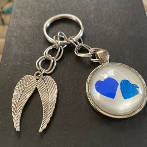 Keychain Angel wings with two blue hearts enclosed